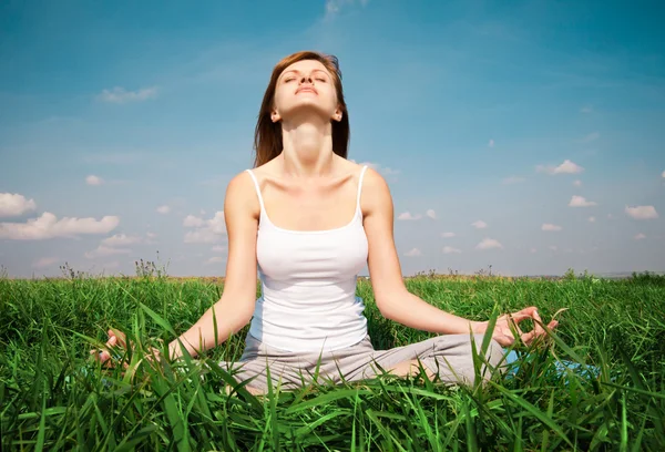 Ung flicka gör lotus yogaställning i parken — Stockfoto