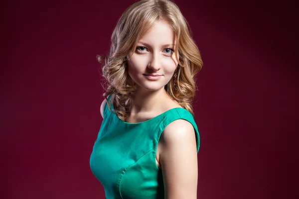 Woman in green dress barefoot on red — Stock Photo, Image