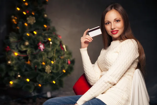 Mujer con tarjeta de crédito delante del árbol de Navidad —  Fotos de Stock