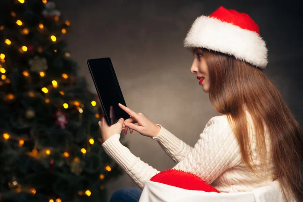 Mulher sentada com tablet PC sobre a árvore de Natal — Fotografia de Stock