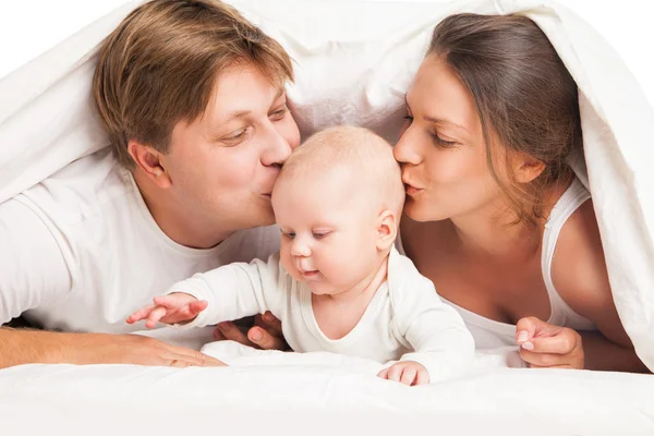 Familia feliz bajo la manta en la cama en casa — Foto de Stock