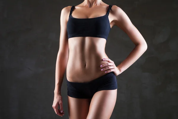 Slanke womans lichaam over donker grijze achtergrond — Stockfoto