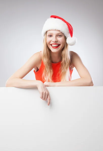 Noel Noel Baba şapkası boş tahta işaret eden kadın — Stok fotoğraf