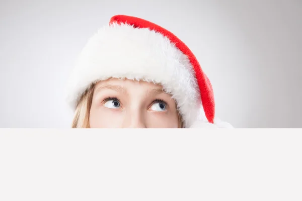 Vánoční žena v santa hat drží prázdná deska — Stock fotografie