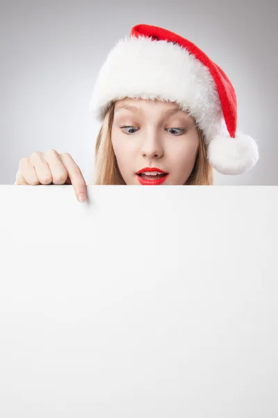 Kerstmis vrouw in Kerstman hoed wijzen leeg bord — Stockfoto