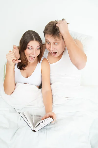 Pregnant woman and her husband reading book — Stock Photo, Image