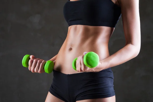 Corpo di giovane donna in forma che solleva i manubri — Foto Stock