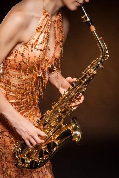 Sexual young woman posing with saxophone at studio — Stock Photo, Image