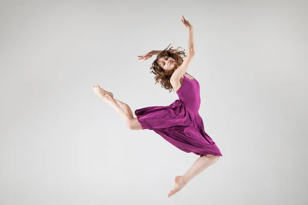 Young ballet dancer wearing purple dress over grey — Stock Photo, Image