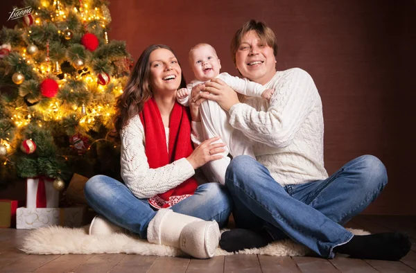 Ευτυχισμένη οικογένεια κοντά χριστουγεννιάτικο δέντρο στο σπίτι — Φωτογραφία Αρχείου