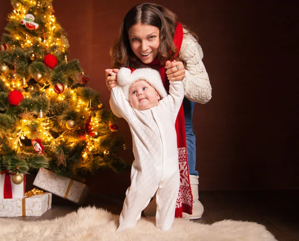 Happy mother and litle baby in santa hats — Stock Photo, Image
