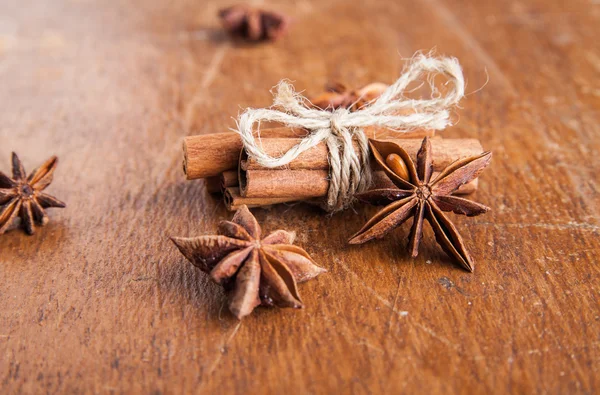 Palitos de canela y anís estrellado sobre madera rústica — Foto de Stock