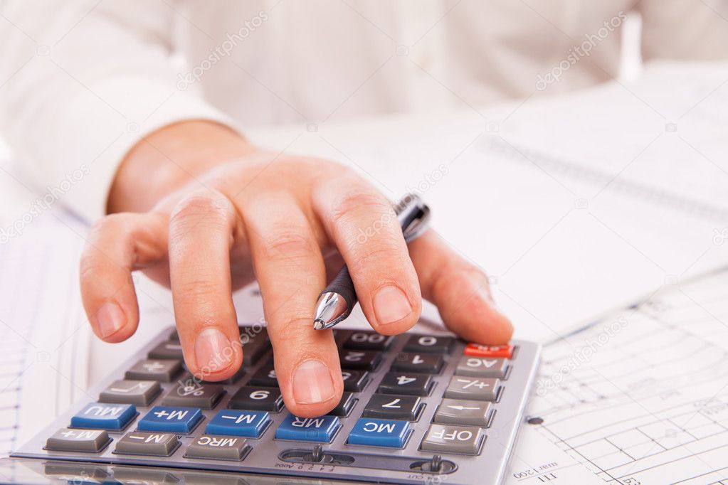 Hands of businessman with calculator