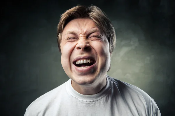 Young angry man over dark grey background — Stock Photo, Image