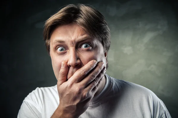 Handsome man scared over dark grey — Stock Photo, Image