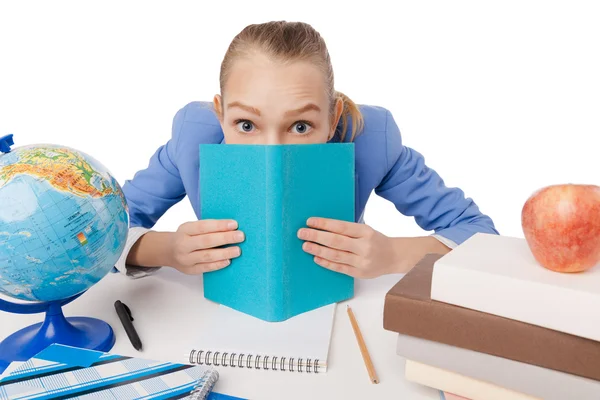 Beautiful girl hiding herself behind a book — Stock Photo, Image