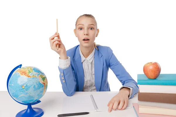 Surprised girl with  pencil sitting at table — Stock Photo, Image