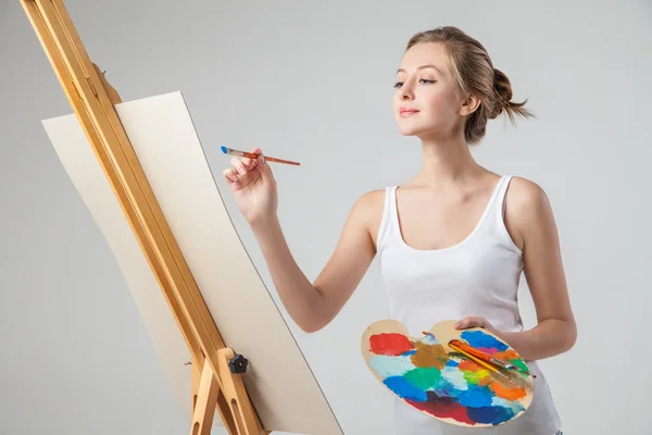 女孩在画布上用油画颜料在白色的涂料 — 图库照片