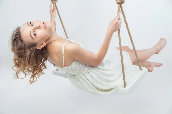 Beautiful young blond woman on a swing. — Stock Photo, Image