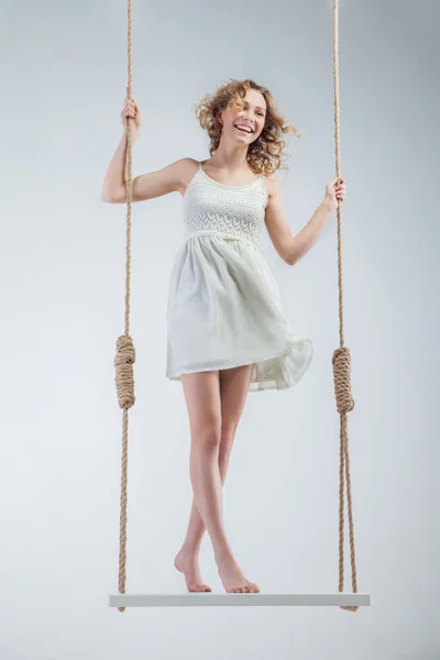 Jeune fille aux pieds nus loughing sur swing — Photo