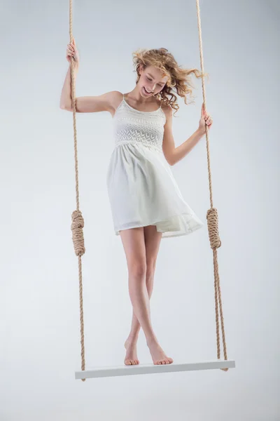 Młoda dziewczyna nagie footed na swing patrząc w dół. — Zdjęcie stockowe