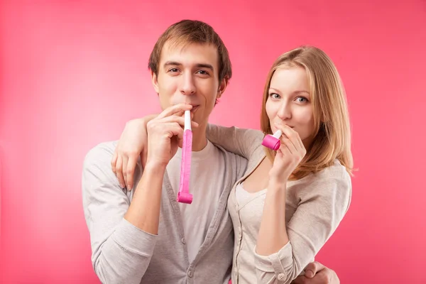 Sonriente pareja con silbatos abrazándose —  Fotos de Stock