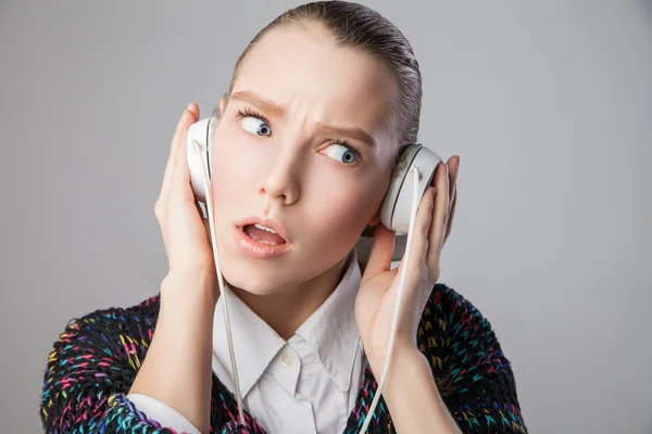 Girl with headphones expressing negative emotions — Stock Photo, Image