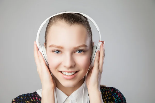 Femme souriante avec écouteurs écoutant de la musique — Photo
