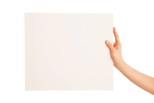 One hand holding a big white piece of cardboard. — Stock Photo, Image