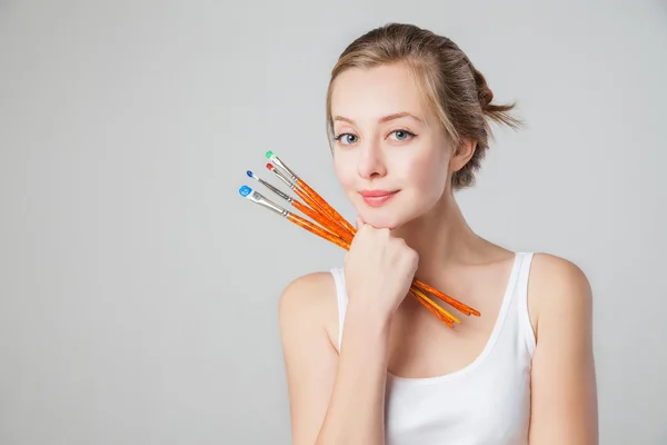 Gros plan d'une artiste-fille souriante avec des pinceaux . — Photo