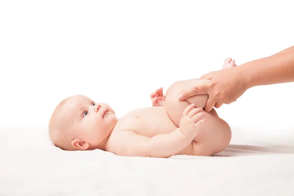 Söt baby liggande. händerna benting hans ben — Stockfoto