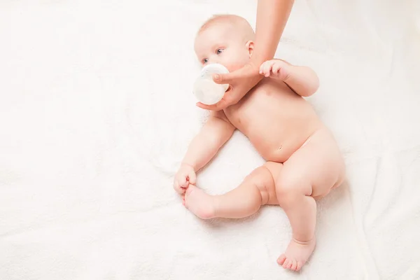 Baby is feeding milk from babys bottle — Stock Photo, Image
