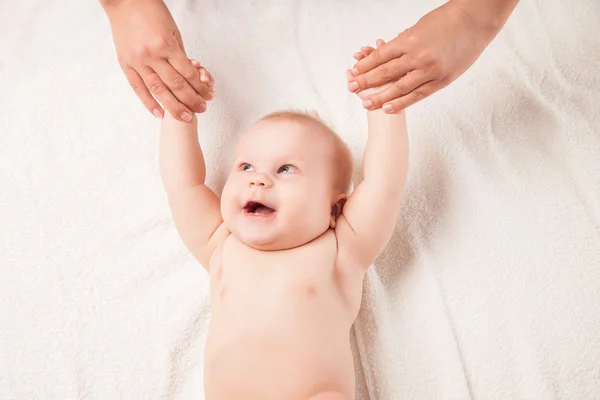 Cute baby lying on white blanket hands lifted — Stock Photo, Image