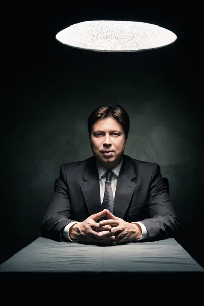 Man wearing suit in dark room illuminated by lamp — Stock Photo, Image