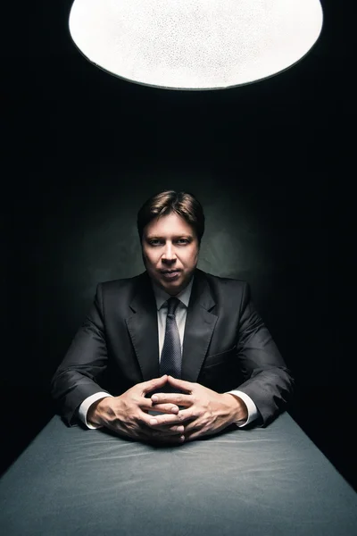 Man wearing suit in dark room illuminated by lamp — Stock Photo, Image