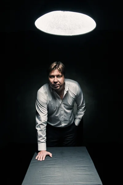 Man in dark room illuminated by lamp — Stock Photo, Image