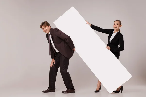 Hombre y mujer de negocios de pie sobre banner en blanco — Foto de Stock