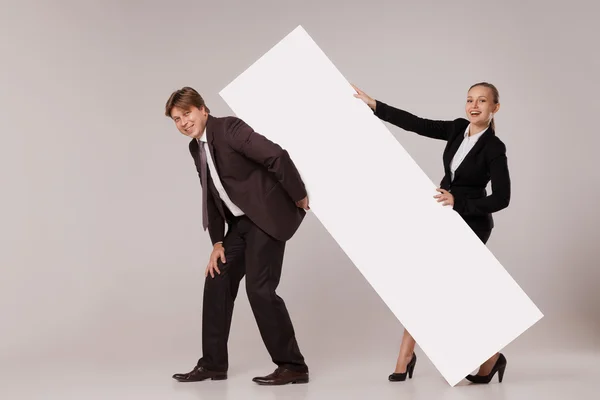 Homem de negócios e mulher em pé sobre banner em branco — Fotografia de Stock