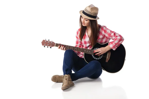 Kobieta muzyk gra na gitarze, siedząc na podłodze. — Zdjęcie stockowe