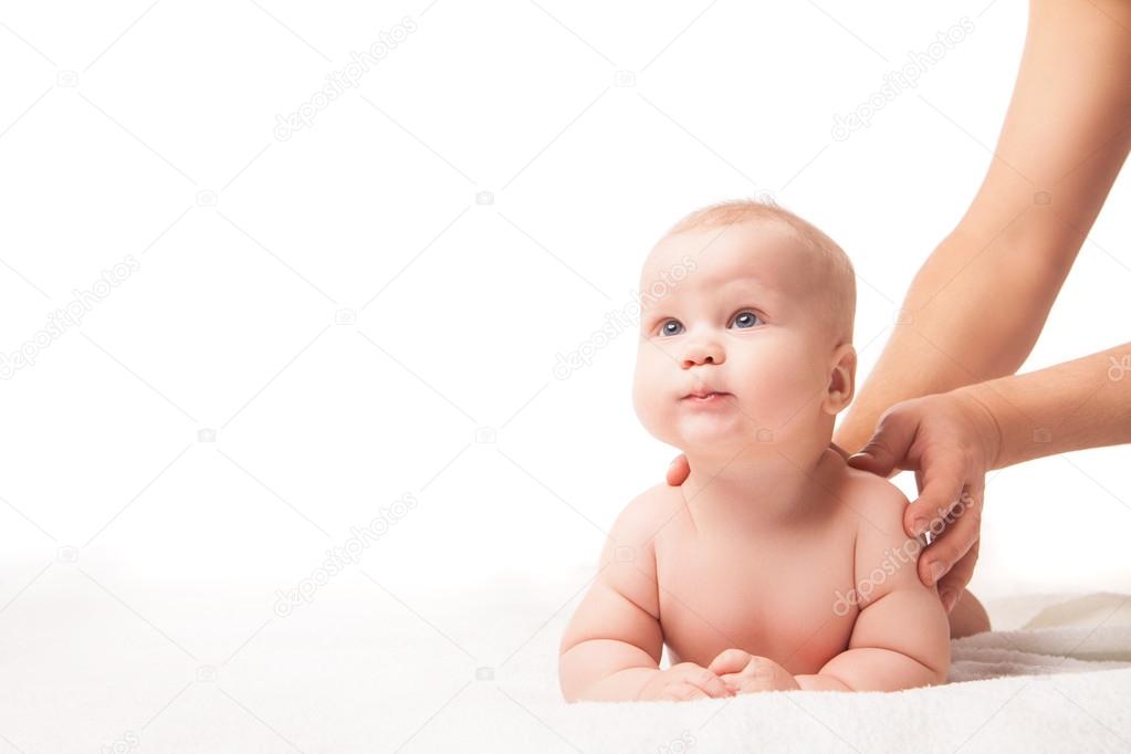 Cute baby lying. hands massaging his neck