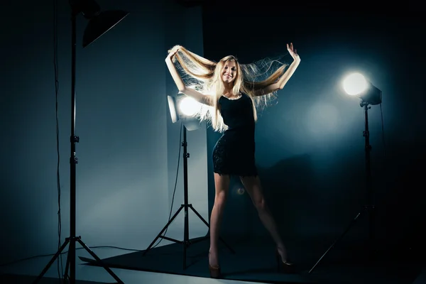 Hermosa mujer posando en el estudio en destellos de luz — Foto de Stock