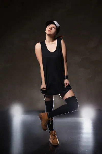 Sexy junge Frau in einem trendigen Kleid über schwarzem Hintergrund — Stockfoto