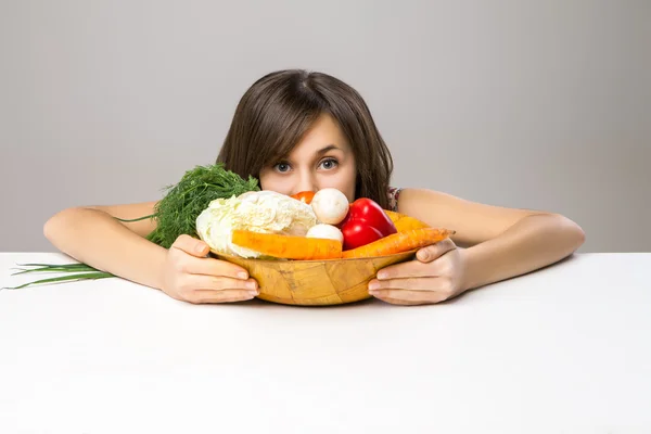 Young woman looking out from cutting board — Stock Photo, Image