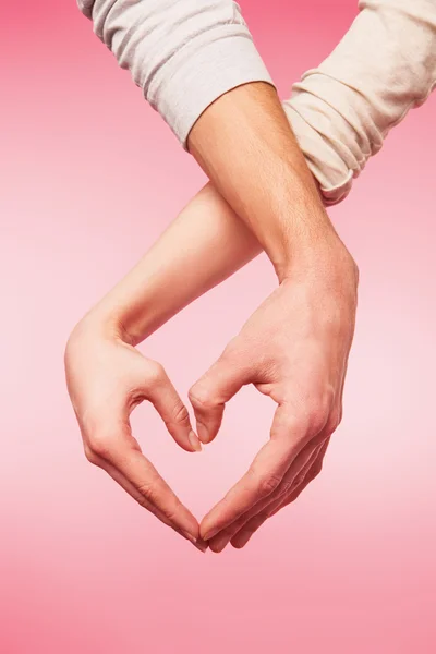 Gros plan des mains de la femme et de l'homme montrant la forme du cœur — Photo