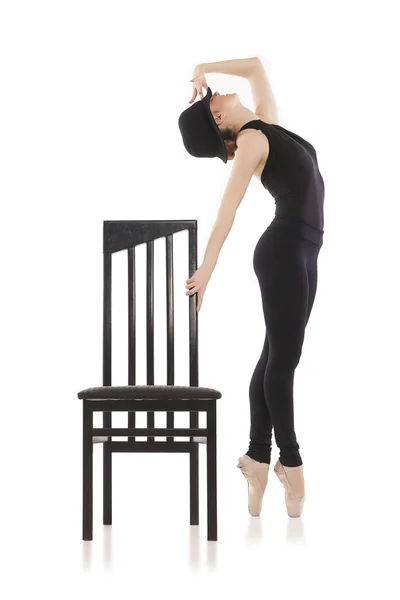 Pretty young ballerina posing with chair. Isolated on white — Stock Photo, Image