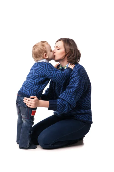 Giovane madre amorevolmente baciare il suo piccolo figlio. isolato su bianco — Foto Stock