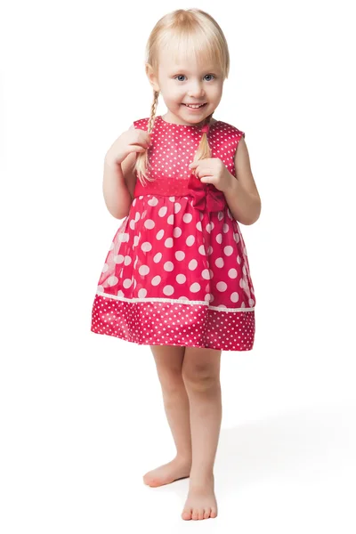 Cute smiling little girl in red dress posing at studio — Stock Photo, Image