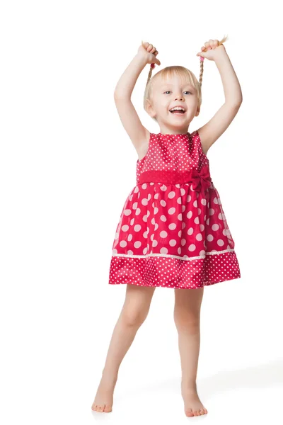 Cute smiling little girl in red dress posing at studio — Stock Photo, Image