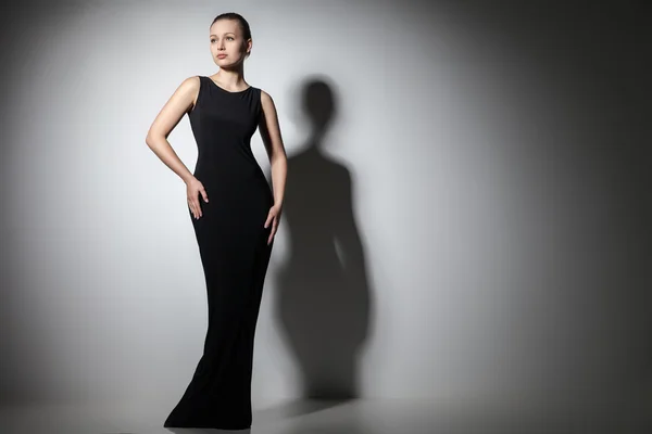 Krásná žena model představuje v elegantní černé šaty — Stock fotografie