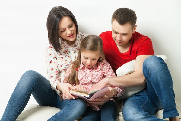 Família feliz. Pais lendo livro com filha — Fotografia de Stock